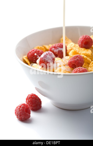 Verser le lait sur muesli avec isolé de framboise Banque D'Images