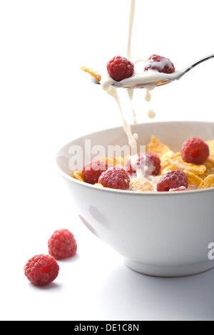 Verser le lait sur muesli avec isolé de framboise Banque D'Images