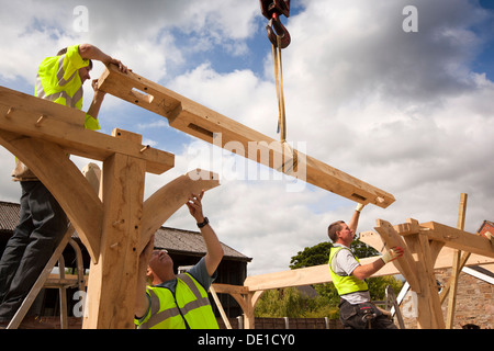 L bâtiment maison, la construction en bois de chêne vert, la structure à l'aide d'embauché grue pour soulever de lourdes cadre en bois Banque D'Images