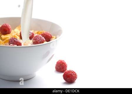 Verser le lait sur muesli avec isolé de framboise Banque D'Images