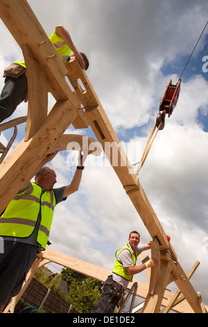 L bâtiment maison, la construction en bois de chêne vert, la structure à l'aide d'embauché grue pour soulever de lourdes cadre en bois Banque D'Images