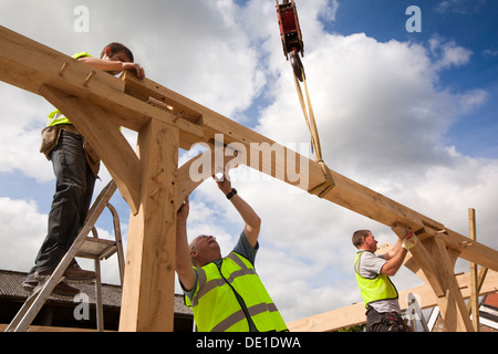 L bâtiment maison, la construction en bois de chêne vert, la structure à l'aide d'embauché grue pour soulever de lourdes cadre en bois Banque D'Images