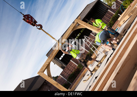 L bâtiment maison, la construction en bois de chêne vert, la structure à l'aide d'embauché grue pour soulever les composants en bois Banque D'Images