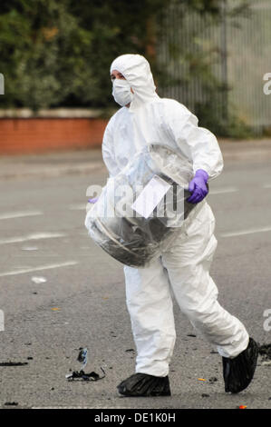 Belfast, Irlande du Nord. 10 septembre 2013 - Un agent d'investigation PSNI emporte la baril de bière qui a été à l'arrière d'un véhicule abandonné dans un sac en plastique. Crédit : Stephen Barnes/Alamy Live News Banque D'Images