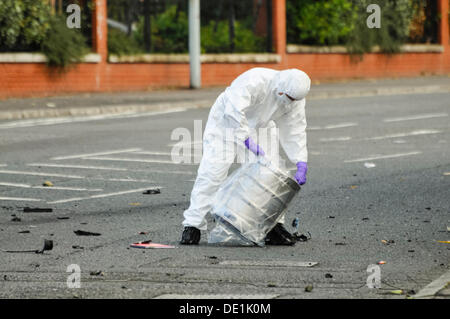 Belfast, Irlande du Nord. 10 septembre 2013 - Un agent d'investigation PSNI scelle le baril de bière, qui a été à l'arrière d'un véhicule abandonné, dans un sac de plastique pour préserver des éléments de preuve. Crédit : Stephen Barnes/Alamy Live News Banque D'Images