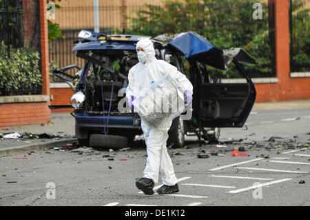 Belfast, Irlande du Nord. 10 septembre 2013 - Un agent d'investigation PSNI emporte la baril de bière qui a été à l'arrière d'un véhicule abandonné dans un sac en plastique. La voiture a été détruit dans une explosion contrôlée. Crédit : Stephen Barnes/Alamy Live News Banque D'Images