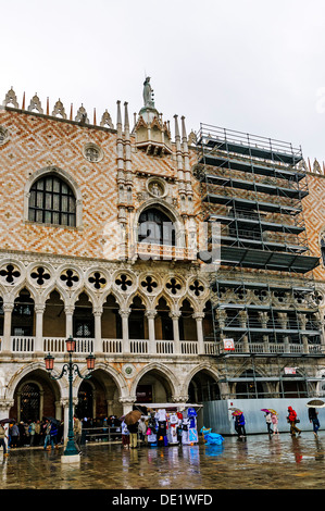 Attente des touristes dans l'arcade pour visiter l'intérieur du palais des Doges et d'éviter la pluie qui tombe sur la Piazzetta di San Marco Banque D'Images