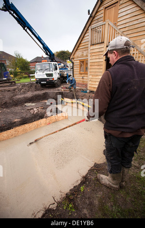 L bâtiment maison, pompage dans des fondations en béton étant tassé level Banque D'Images