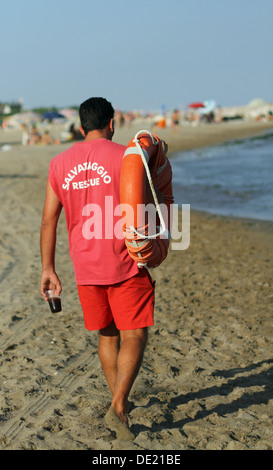 Maître-nageur sur la plage avec un verre de soda et gareautrain Banque D'Images