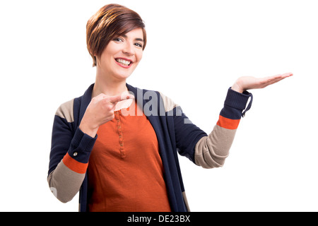 Belle femme heureuse en pointant sur sa main gauche, isolé sur fond blanc Banque D'Images