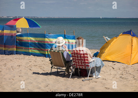 Studland beach avec couple détendu près de brise-vent, l'île de Purbeck, Dorset, England, UK. Banque D'Images