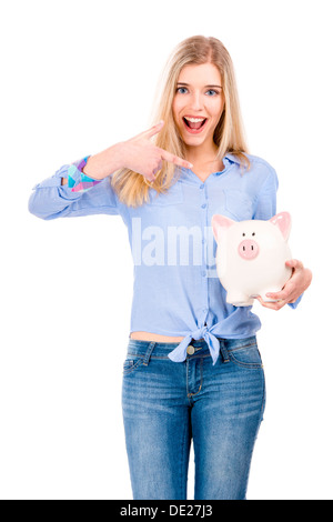 Belle et séduisante blonde woman holding et en pointant à une tirelire, isolé sur fond blanc Banque D'Images