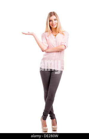 Belle jeune femme en souriant et montrant la paume de sa main droite, isolé sur fond blanc Banque D'Images