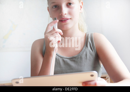 Girl holding d'un iPad et d'un connecteur USB Banque D'Images