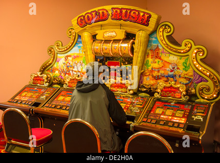 L'homme jouant sur des machines à sous. Banque D'Images