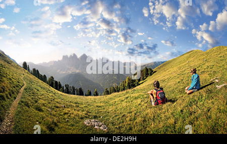 Les randonneurs dans un pré de détente en profitant de la vue du groupe Geisler, Aferer Geisler montagnes, Villnoesstal valley Banque D'Images