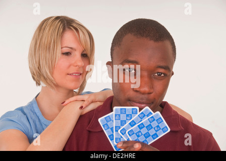 Jeune homme à la peau sombre et jeune femme européenne cartes à jouer Banque D'Images