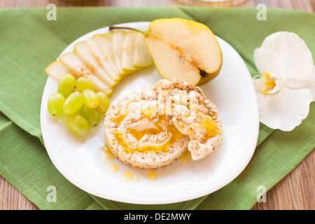 Craquelins de maïs avec du miel et des fruits Banque D'Images