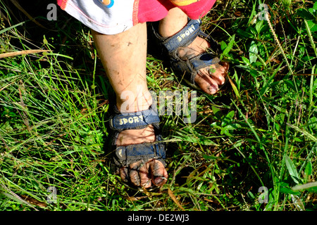 Petit garçon a pieds humides et boueuses après une marche à travers une rizière à Java en Indonésie Banque D'Images