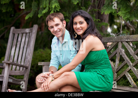 Young Caucasian couple sitting on park bench Banque D'Images