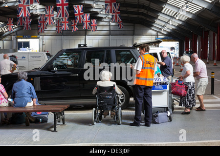 Les passagers en fauteuil roulant au départ Croisière Croisière reçoit le soutien du personnel de première ligne. Royaume-uni Southampton Banque D'Images