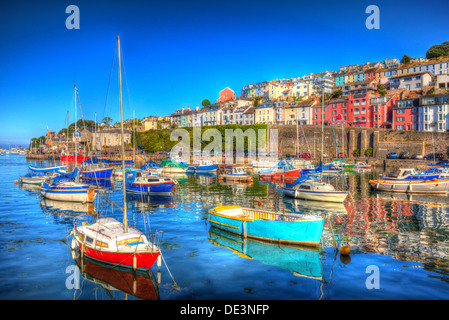 Les bateaux aux couleurs vives avec ciel bleu et la mer du port de Brixham Devon avec des maisons sur la colline en arrière-plan dans HDR Banque D'Images