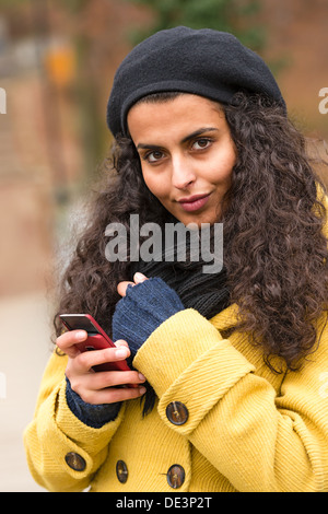 Femme souriante en utilisant son téléphone dans la forêt d'automne Banque D'Images