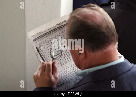 Hambourg, Allemagne, l'homme lit son journal avec une loupe Banque D'Images