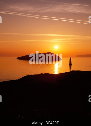 Penmon, Anglesey, Penmon Point Lighthouse, perche Rock & l'île de macareux juste après le lever du soleil, à l'ENE à travers la baie de Conwy pour le Great Orme à Llandudno. Banque D'Images