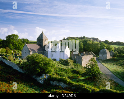 Penmon Prieuré, Anglesey : St Seiriol's C12e et 13e avec l'ancienne église du logement avant (maison blanche) et gamme de dortoir, et plus tard pigeonnier (c 1600). Banque D'Images