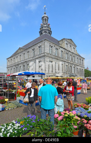 Place du marché de Maastricht surplombée par les vendeurs de fleurs historiques de l'hôtel de ville au travail et les acheteurs regardant des fleurs à vendre dans le Limbourg ensoleillé pays-Bas UE Banque D'Images