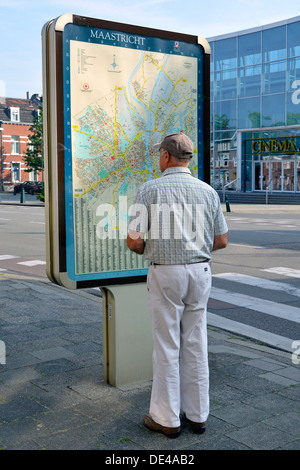 Maastricht carte de rue sur le panneau d'information routière vue arrière de visite modèle libéré touriste homme vérifiant l'emplacement Limbourg pays-Bas Europe UE Banque D'Images