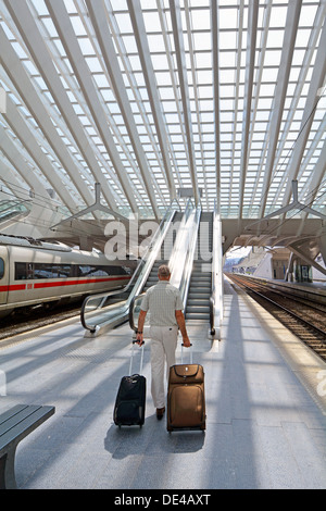 Autorisation modèle senior man des personne qui marche avec valise bagages sur la plate-forme Liège gare escalator bâtiment moderne en verre Banque D'Images