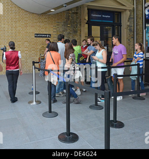 Attente des fans d'avoir une photo prise à la plate-forme neuf et trois quarts signe de Harry Potter story à Kings Cross station Banque D'Images