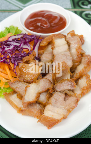 Porc frit servi avec légumes frais et sauce rouge Banque D'Images