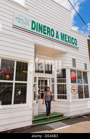 WOODBURN, Oregon, USA - femme quitte le magasin avec Dinero un signe que le Mexique offre des services de remise de fonds pour les immigrés mexicains. Banque D'Images