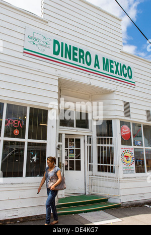 WOODBURN, Oregon, USA - femme quitte le magasin avec Dinero un signe que le Mexique offre des services de remise de fonds pour les immigrés mexicains. Banque D'Images