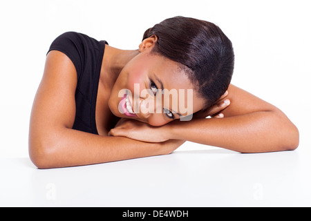 Belle jeune femme africaine portant sur un bureau sur fond blanc Banque D'Images