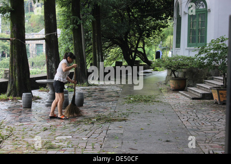 Femme de feuilles de compensation sa cour. Banque D'Images