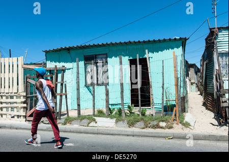 Une personne qui marche sur la route à Khayelitsha, un township informel partiellement à Cape Town, Western Cape, Afrique du Sud Banque D'Images