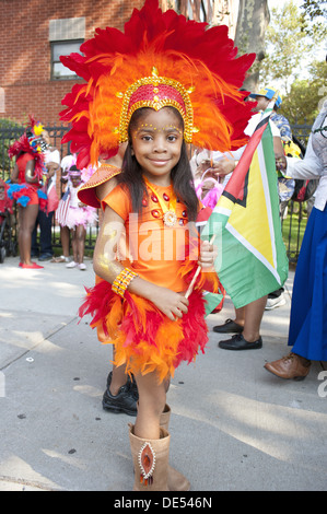 2012 West Indian/Caraïbes Kiddies parade, Crown Heights. Jeune fille en costume est titulaire d'un drapeau du Guyana. Banque D'Images