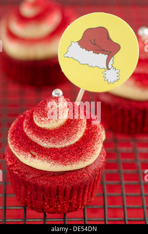 Cupcake rouge avec une décoration de Noël et twirl crème Banque D'Images