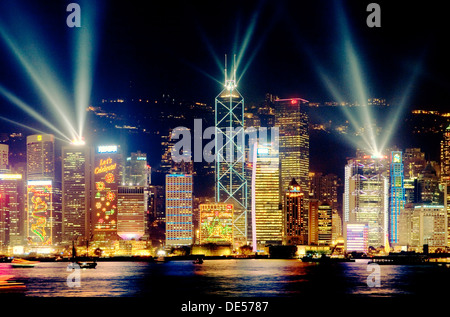 L'île de Hong Kong, Chine sur les toits de la ville de District Central de nuit avec éclairage laser spectacle vu à travers le port de Victoria à partir de Kowloon Banque D'Images
