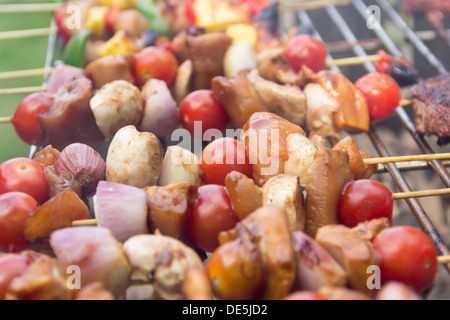 Brochettes de poulet cuisson sur un grand barbecue au charbon pour une partie. Banque D'Images