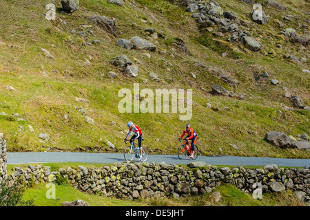 Les cyclistes gravir les pentes Wrynose Pass dans le Lake District Banque D'Images