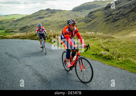 Les cyclistes gravir les pentes Wrynose Pass dans le Lake District Banque D'Images