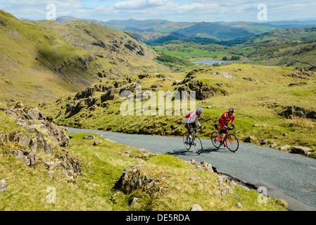 Les cyclistes gravir les pentes Wrynose Pass dans le Lake District avec peu derrière Langdale Banque D'Images