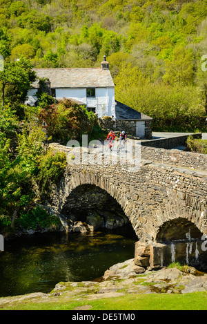 Les cyclistes sur Ulpha Bridge dans la vallée de Duddon dans le Lake District Banque D'Images