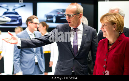 Francfort, Allemagne. 12e Août, 2013. La chancelière allemande, Angela Merkel (CDU, R) est accompagnée par le président du constructeur automobile Opel, Karl-Thomas Neumann, tels qu'ils se présentent à l'Opel stand lors de Merkel, tour à travers la 65ème Salon Automobile International Fankfurt (IAA) à Francfort, Allemagne, 12 septembre 2013. L'AAI est considéré parmi l'un des plus importants salons automobiles dans le monde entier et se déroule du 12 septembre au 22 septembre 2013. Photo : Daniel Reinhardt/dpa/Alamy Live News Banque D'Images