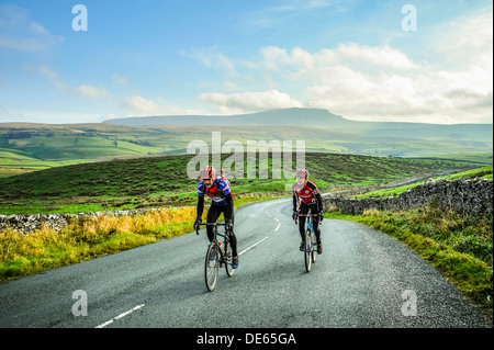 Les cyclistes en Ribblesdale dans le Yorkshire Dales National Park avec Pen-y-Ghent derrière Banque D'Images